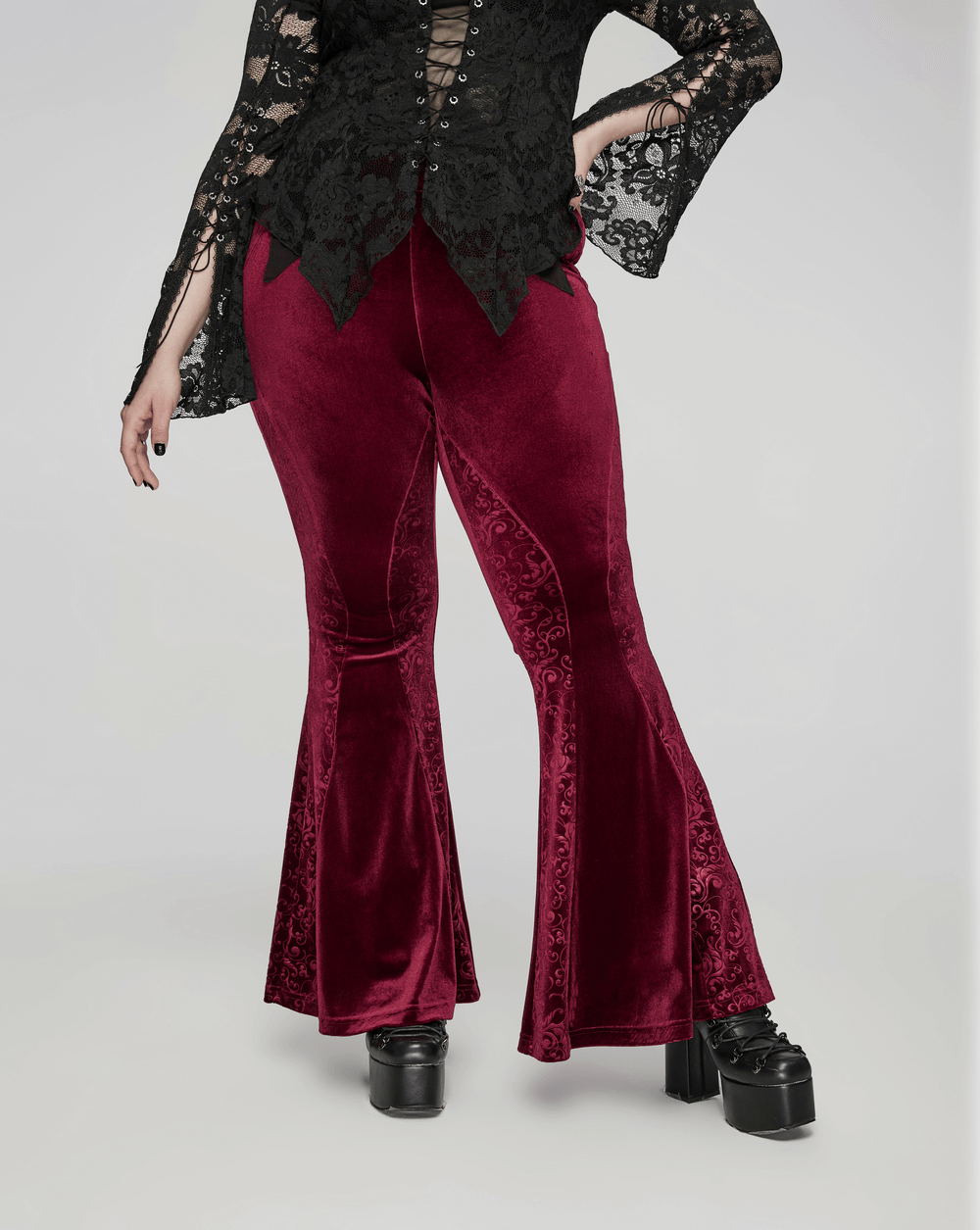 Gothic burgundy velvet flared pants with embossed details, stylishly paired with a black lace top.
