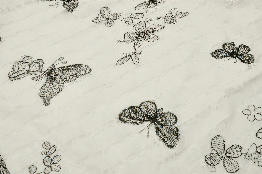 Gothic butterfly lace print showcasing intricate floral and butterfly designs on a light background.