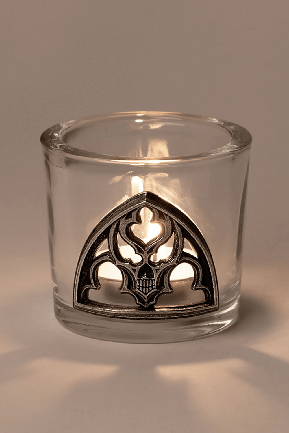 Gothic glass candle holder with pewter skull accent, perfect for dark home decor and eerie ambiance.