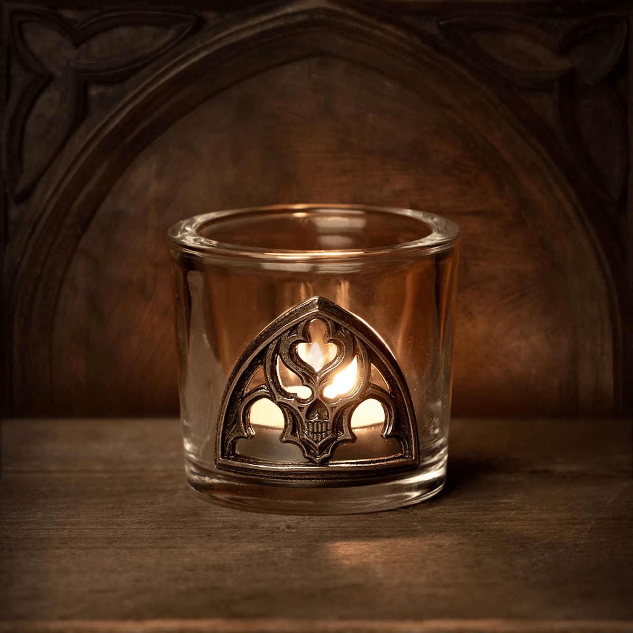 Gothic glass holder with pewter skull detail, illuminating an eerie ambiance for home decor.