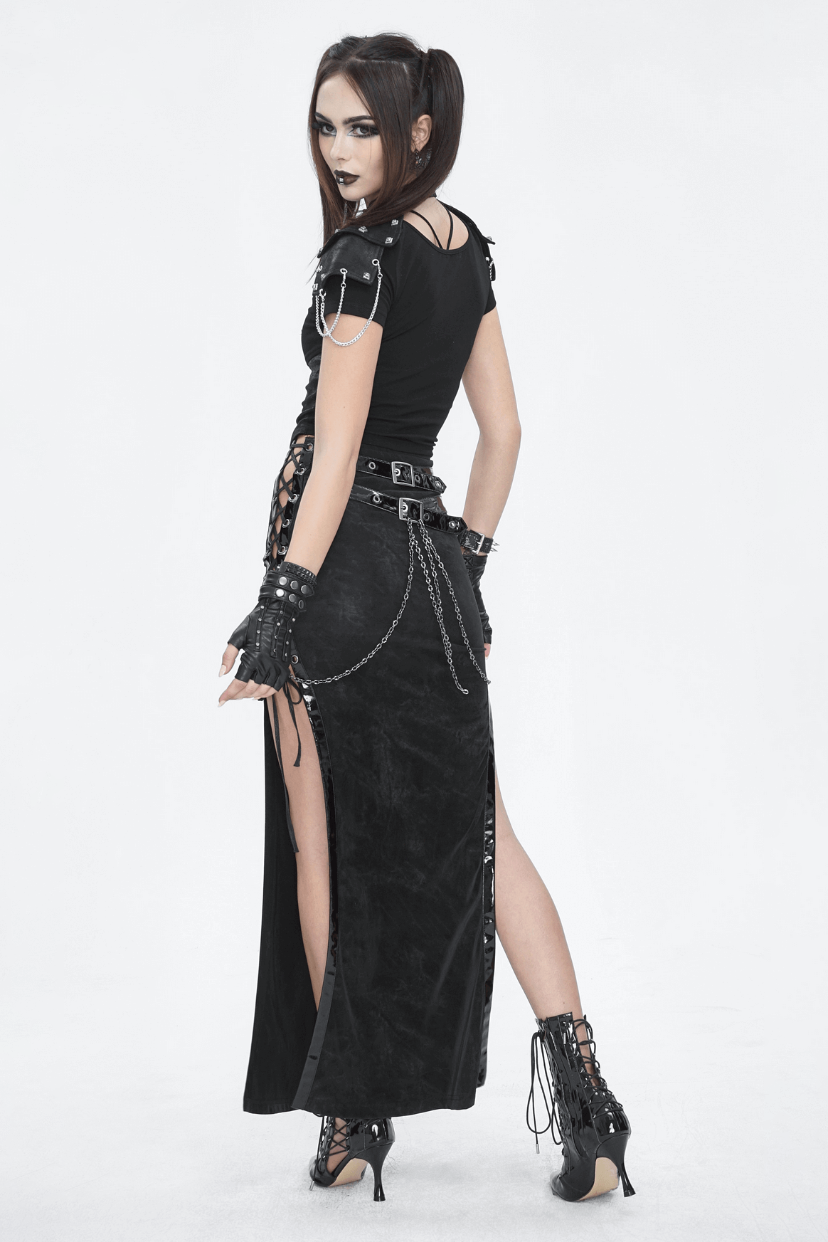 Gothic crop top with shoulder accents and chain details, paired with a black skirt and edgy accessories.