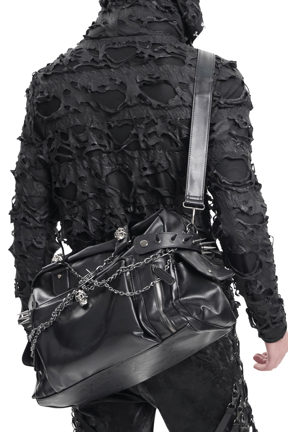 Gothic fashion statement featuring a black tote bag with chains and skulls, paired with a shredded black jacket.