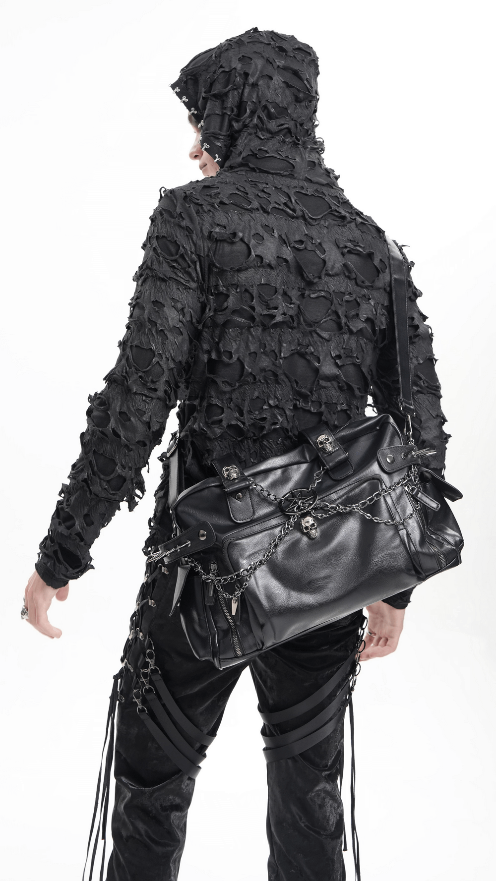 Edgy model showcasing a gothic chain embellished black tote bag with skulls and spikes, perfect for alternative fashion lovers.