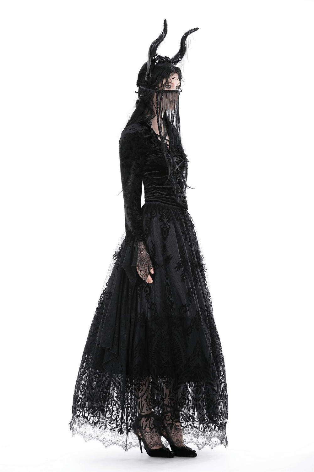 Gothic chic model in black lace maxi skirt with dramatic floral details and a whimsical horned headpiece.
