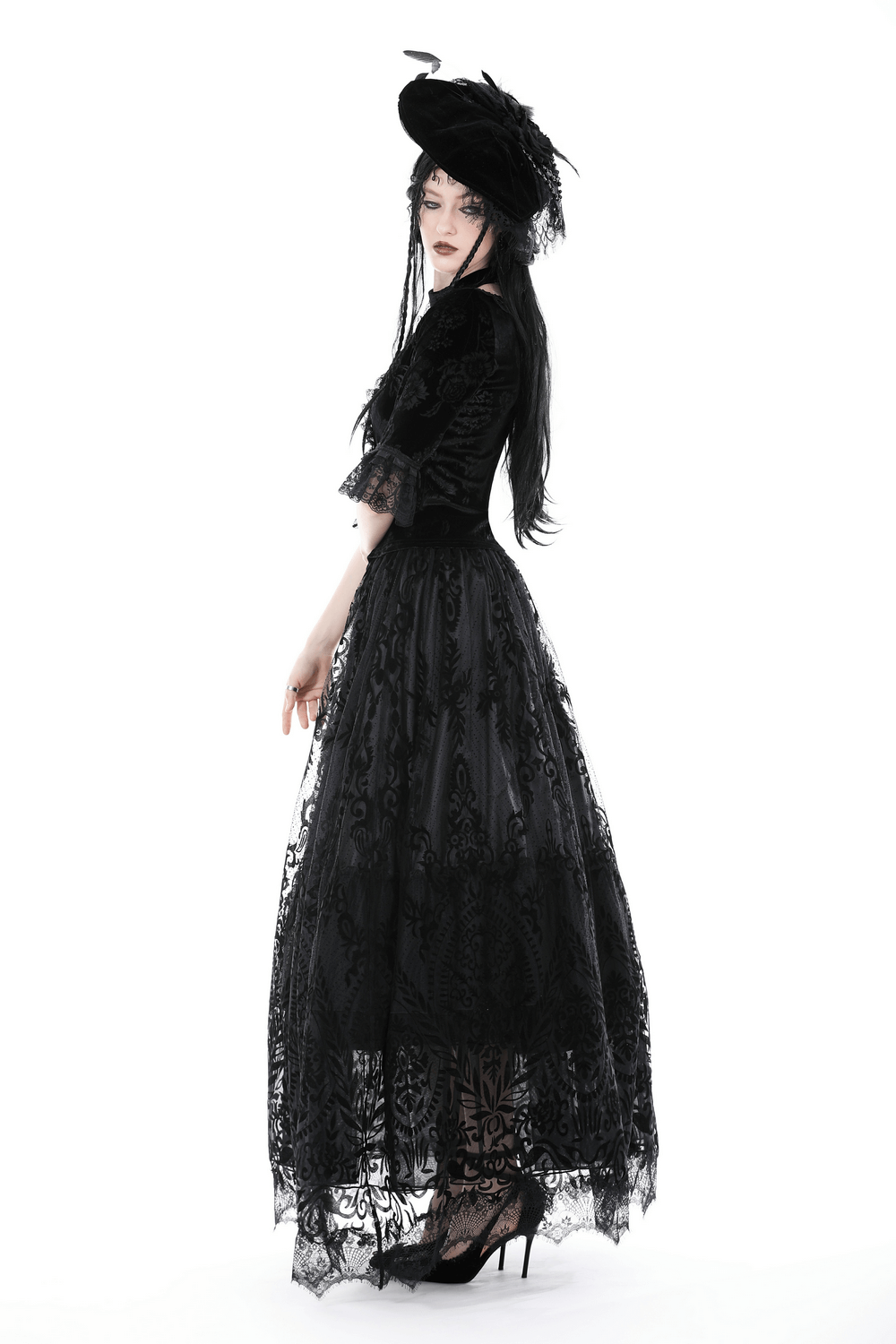 Elegant model in Gothic chic black lace maxi skirt with ornate damask pattern and dramatic hat.