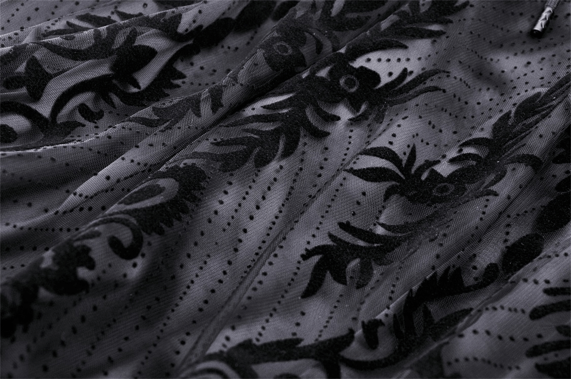 Close-up of black lace fabric featuring intricate floral damask pattern, perfect for a gothic chic look.
