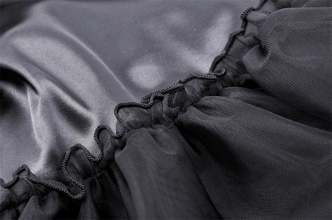Close-up of flowing black lace fabric with delicate ruffled edges, perfect for a gothic chic maxi skirt.