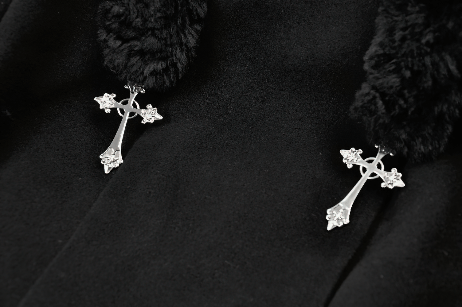 Close-up of silver cross pendants on a Gothic Coat with Plush Faux Fur Cuffs and Cat Ear Hood.