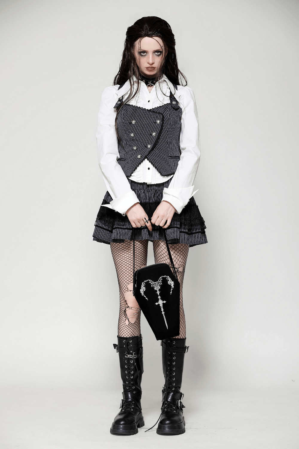 Model showcasing a gothic style with a coffin bag featuring an embroidered sword, perfect for dark aesthetics.