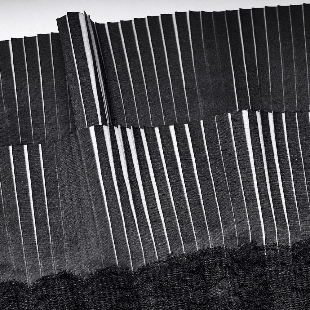 Close-up of crimped black collar fabric with white stripes for a gothic fashion look.