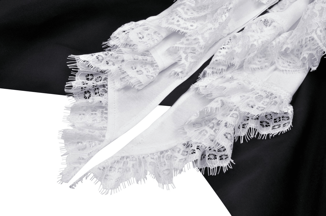 Close-up of white lace trim on a black gothic cropped jacket, showcasing stylish detailing and texture.