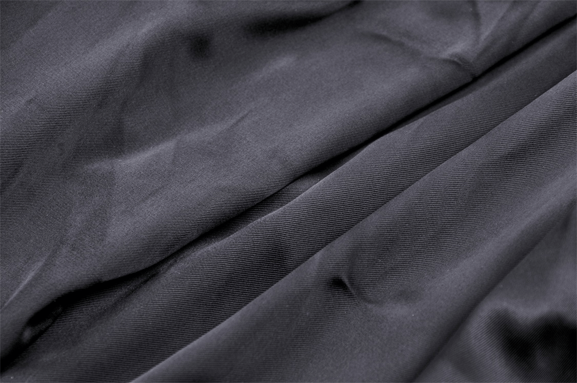 Close-up of luxurious black fabric showcasing smooth texture and drape.