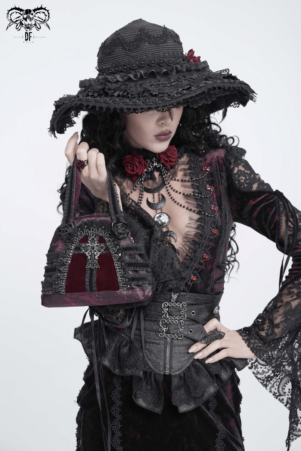 Gothic Cross Velvet Handbag with Ruffle Trim Details showcased by a model in Victorian attire with accessories.