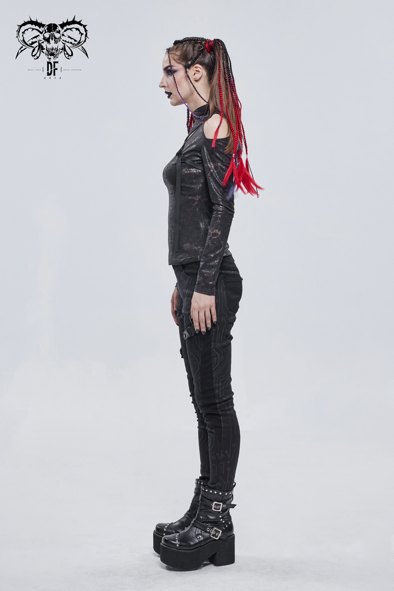 Stylish gothic woman in a black cutout top and pants, showcasing an edgy alternative fashion look.