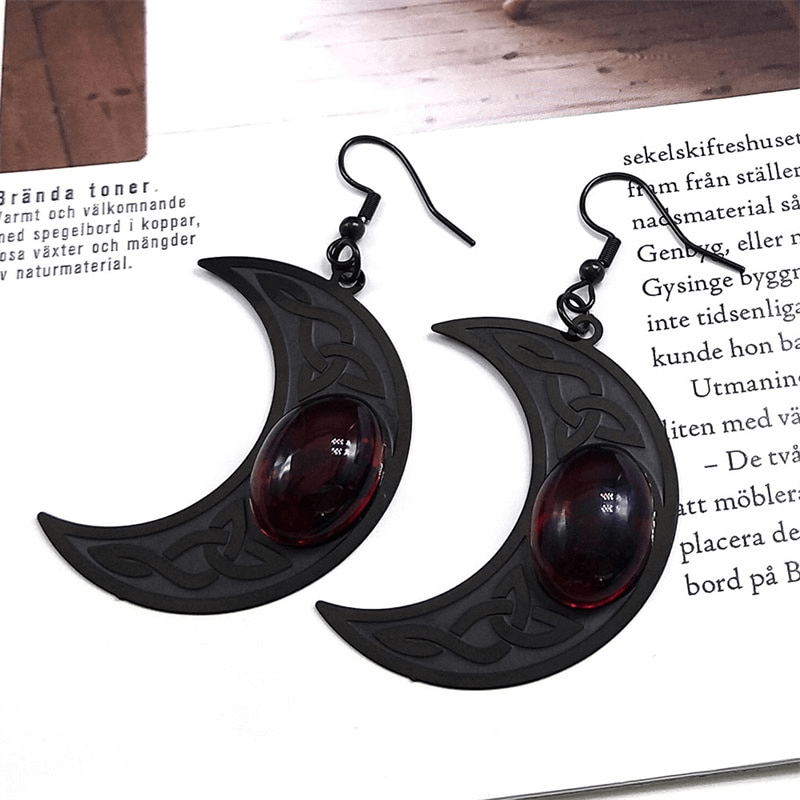Gothic dark Celtic earrings for women with stainless steel crescent shape and red stone accent.