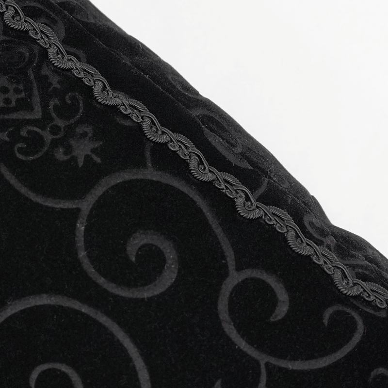 Close-up of gothic black coffin-shaped cushion with elegant T-lace trim and textured black fabric design.