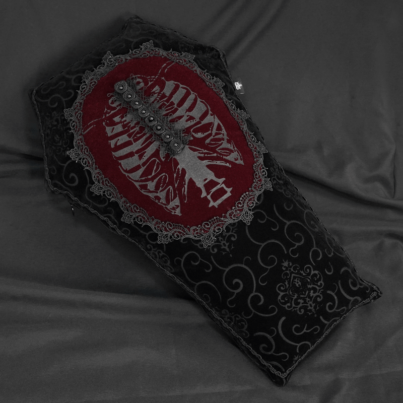Gothic coffin-shaped cushion with black lace trim and red skeleton design, perfect for unique home decor.