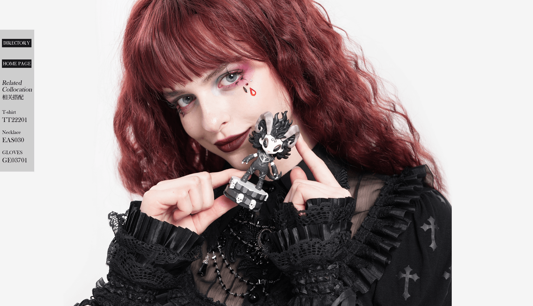 Woman in gothic attire holding a whimsical figure, showcasing a unique style with red hair and dark accessories.