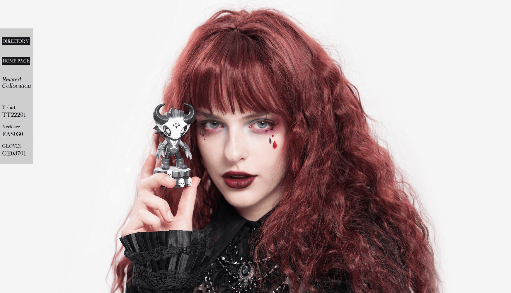 Gothic demon figure with horns held by a model with striking red hair and dramatic makeup, presenting a collectible.