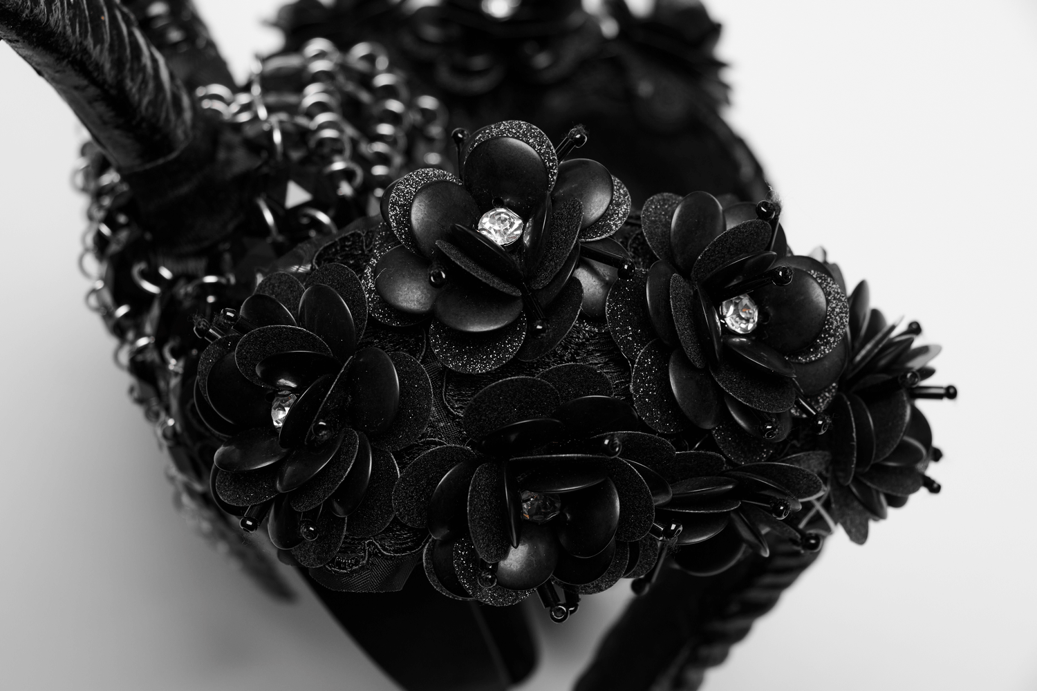Gothic demon horn headwear adorned with black glitter flowers and shimmering accents for dark glamour.