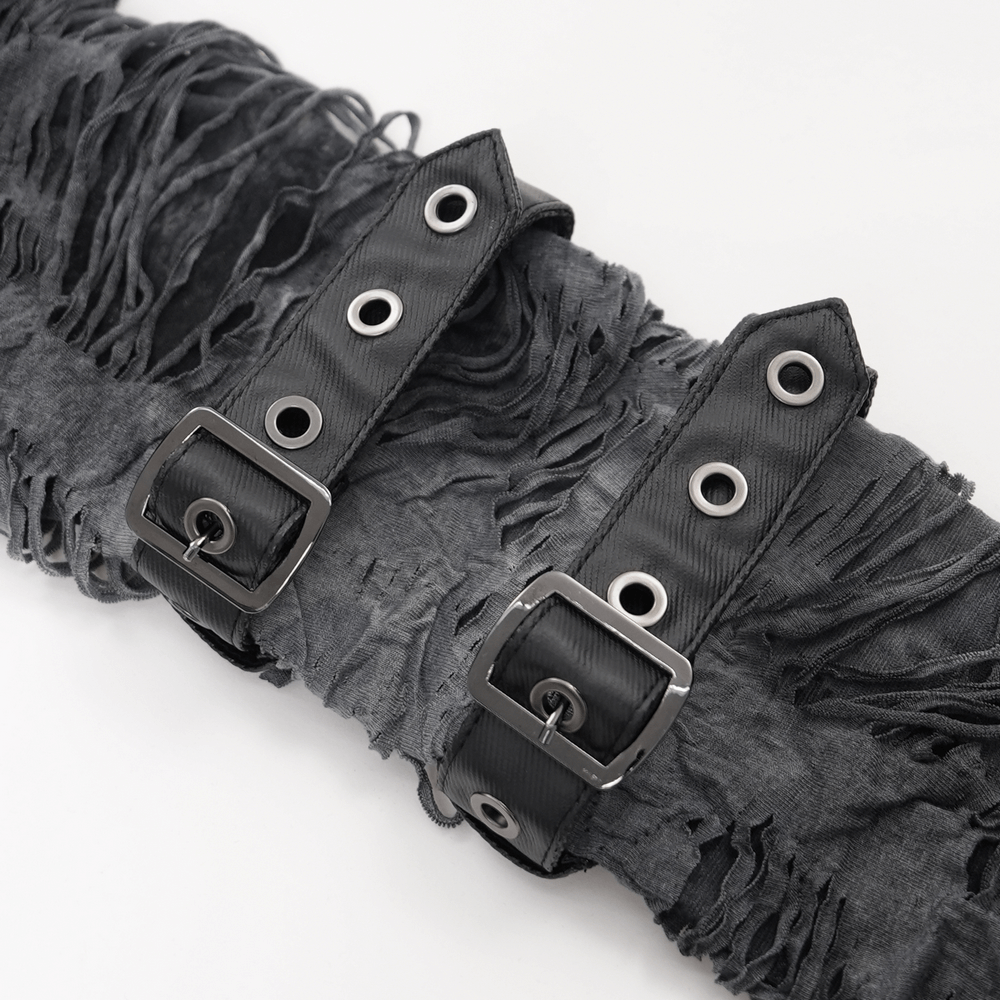 Close-up of distressed black fabric with straps and buckles, showcasing punk rock details for gothic fashion.