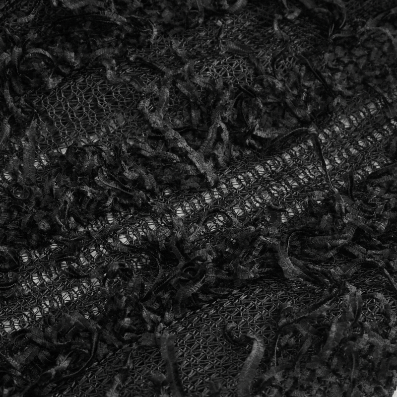 Close-up of gothic distressed sheer sweater fabric, featuring textured black strands and intricate detailing.