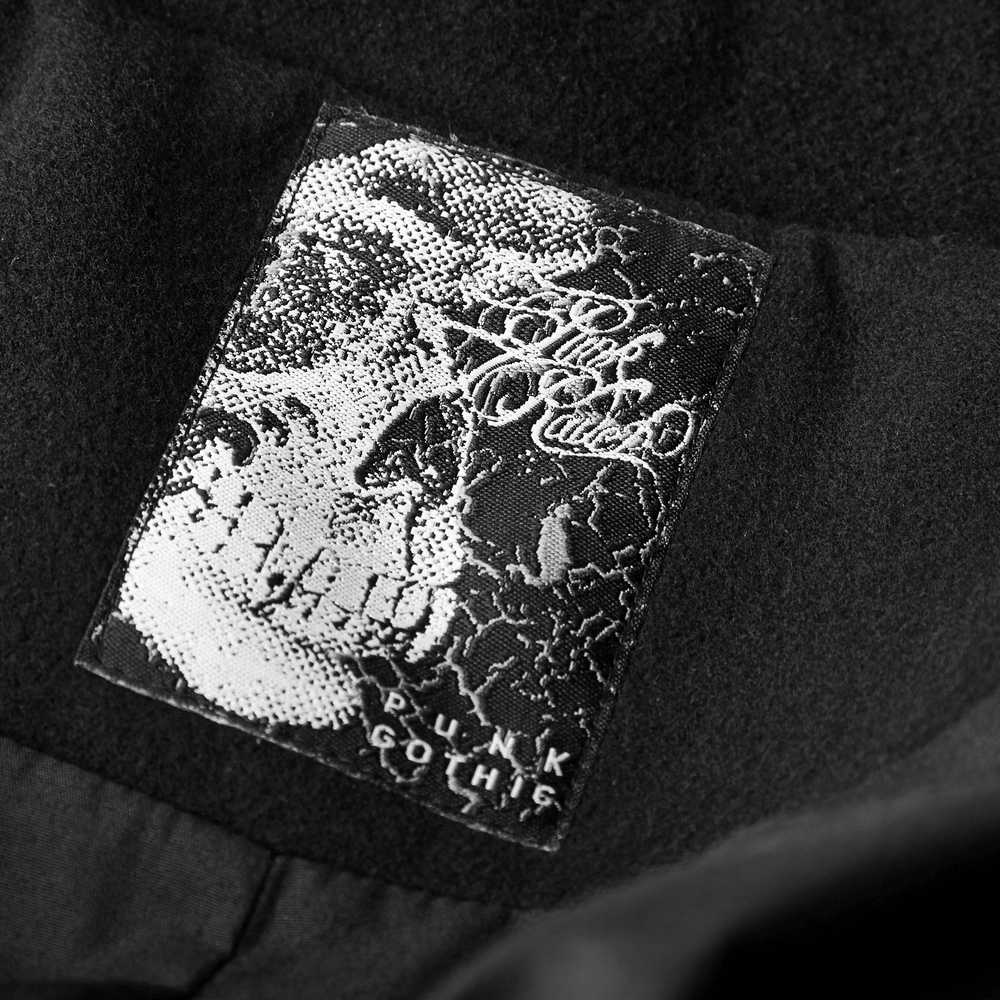 Close-up of a punk gothic label featuring a skull design on a black background.