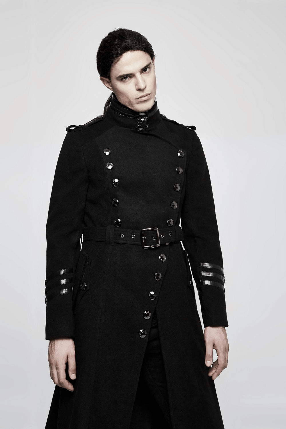 Gothic double-breasted coat with belt and metal accents on model, showcasing military-inspired design and stylish details.