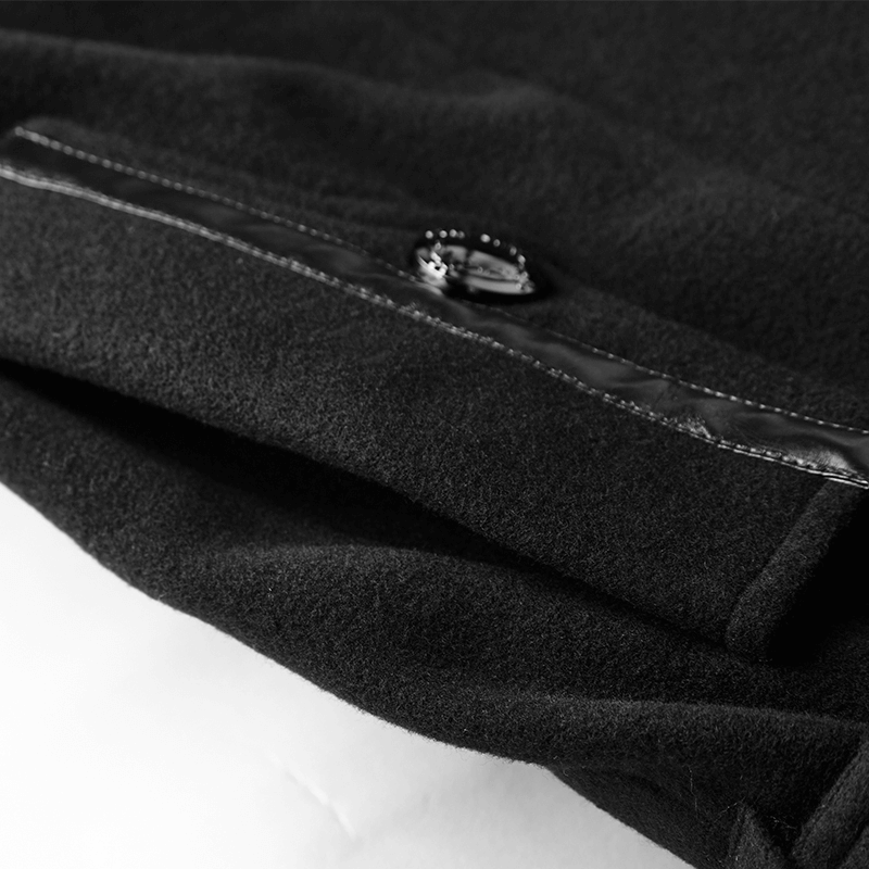 Close-up of black gothic double-breasted coat fabric with metal button and sleek detailing.