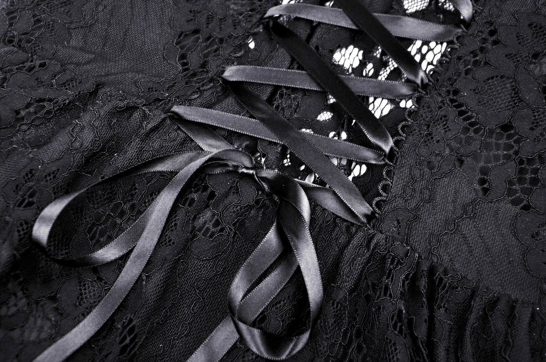 Close-up of black lace dress with satin ribbons and intricate detailing for a gothic, romantic look.