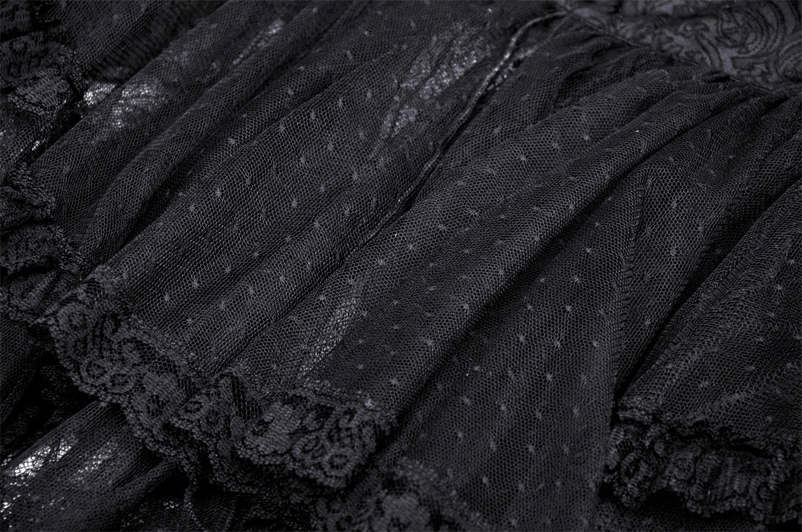 Close-up of black lace fabric showcasing ruffle detailing and textured polka dots for a gothic dress.