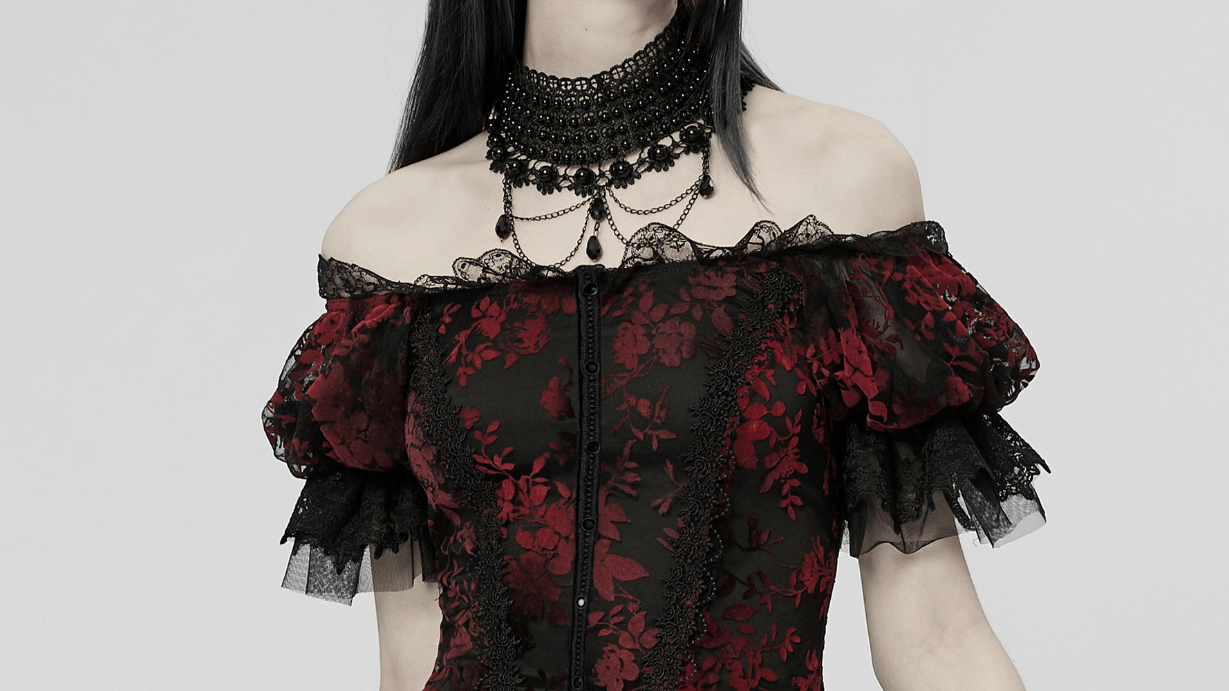 Gothic elegance: Red and black floral mesh gown with off-shoulder sleeves and intricate lace details.
