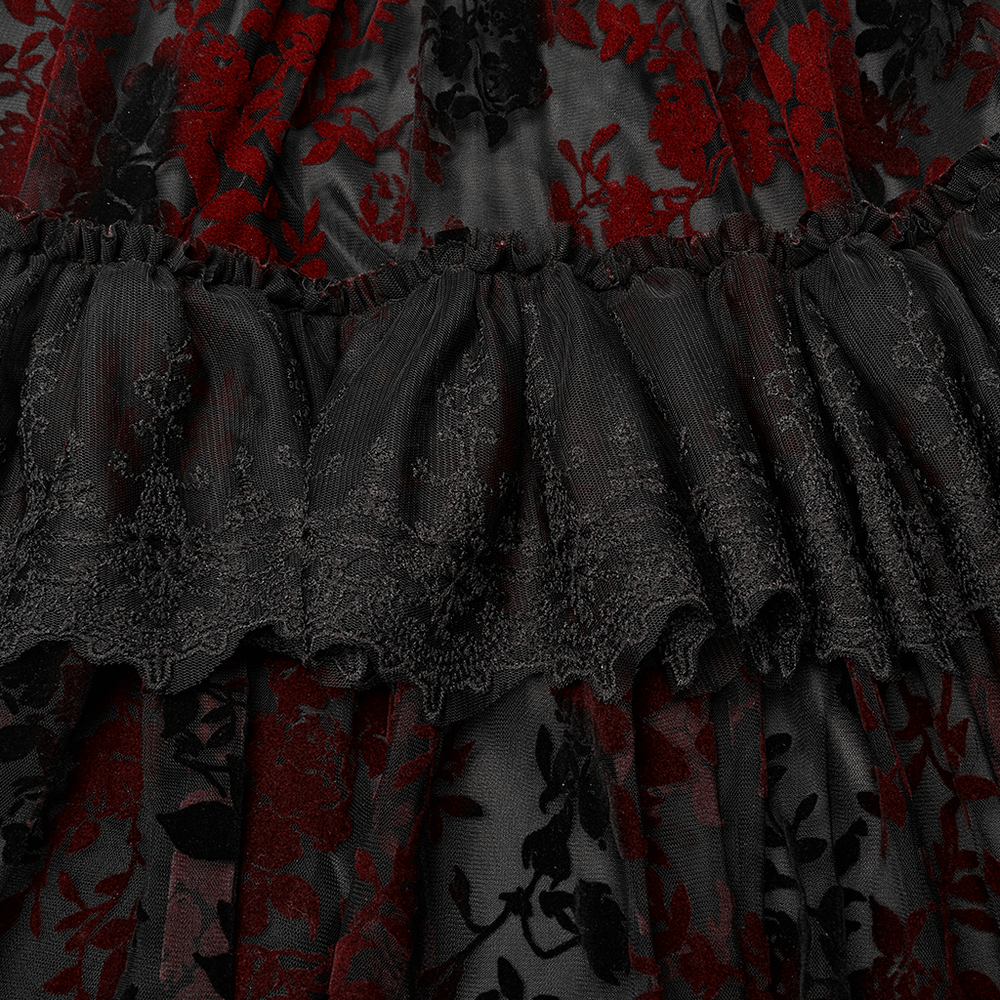 Close-up of Gothic Elegance gown showcasing intricate flocking print and ruffled detail in red and black.
