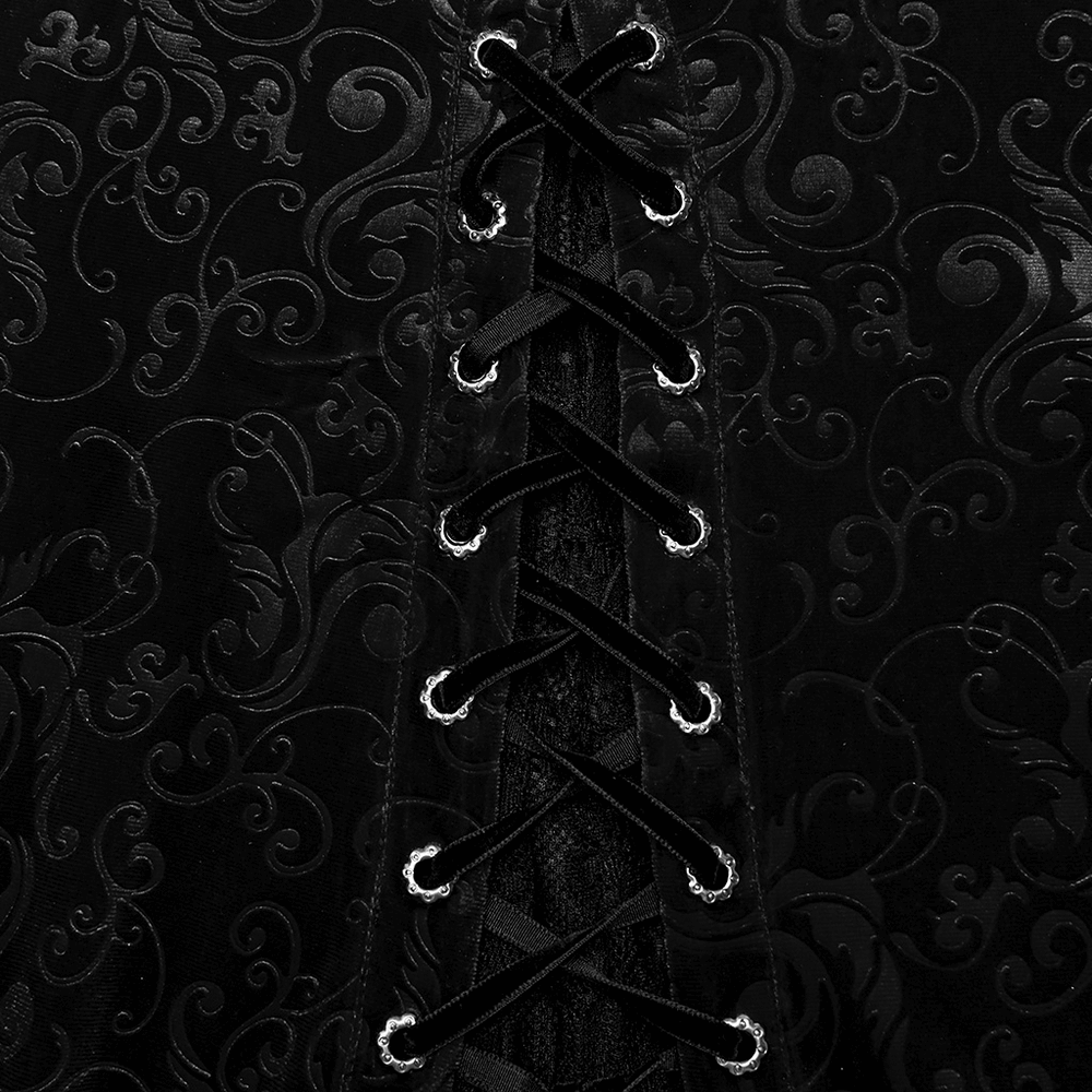 Close-up of black embossed velvet dress lace-up detailing, showcasing intricate patterns and luxurious fabric.