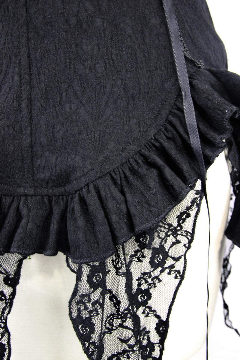 Close-up of black gothic shirt showing lace inserts and ruffled hem, perfect for vintage-inspired fashion.