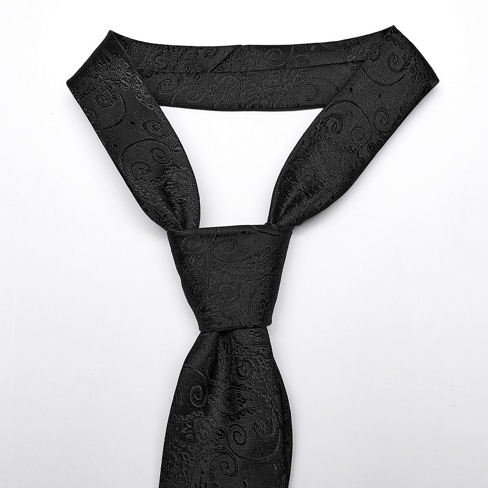 Elegant black jacquard cross tie with intricate paisley pattern, perfect for a gothic aesthetic.