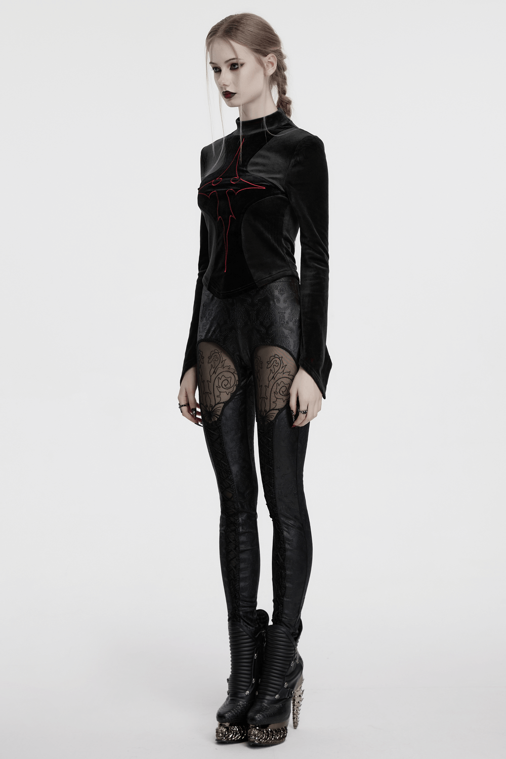 Gothic embossed hollow out leggings with butterfly pattern and vertical drawstrings, styled with a black top and edgy boots.