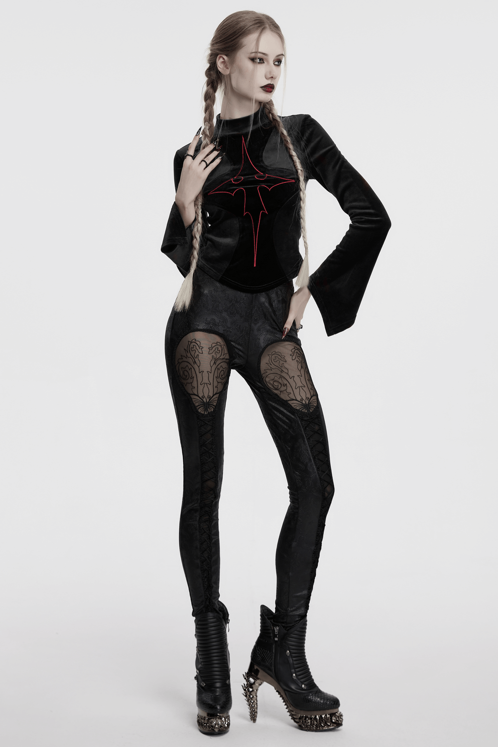 Gothic embossed hollow out leggings with butterfly design, styled with a black top and edgy boots.