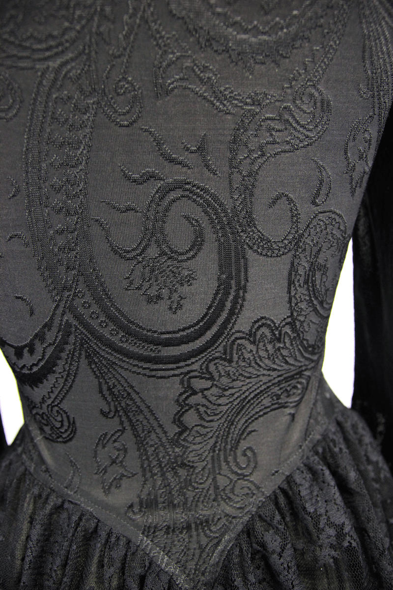 Intricate black paisley pattern detailing on a gothic-style women's top, showcasing elegance and vintage charm.