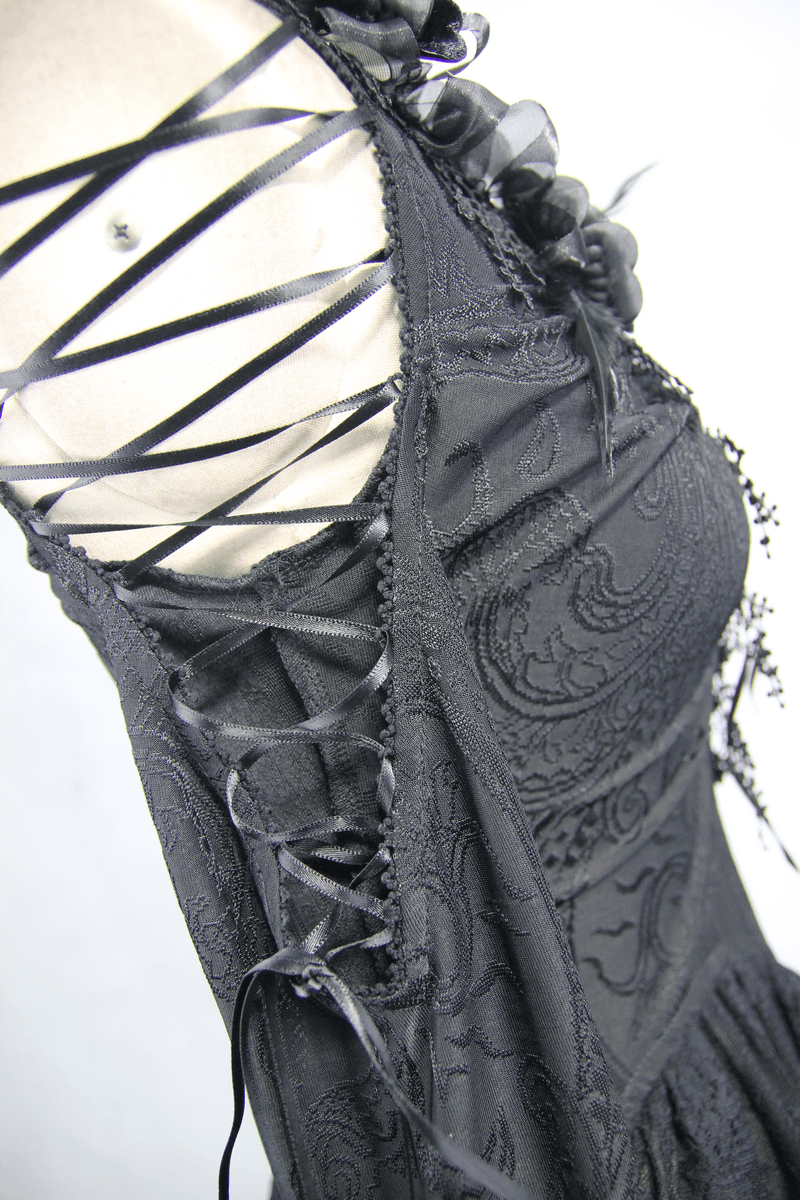 Close-up of gothic black top detailing with elegant lace-up side and floral accents, showcasing vintage style.