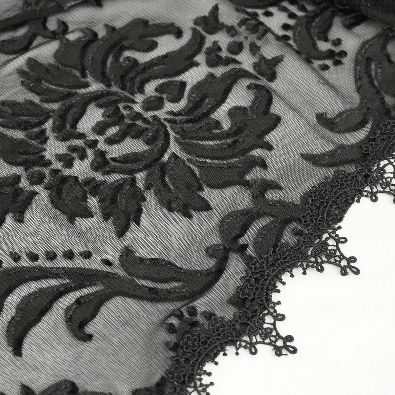 Close-up of intricate black gothic embroidery and lace details on a stylish cape.