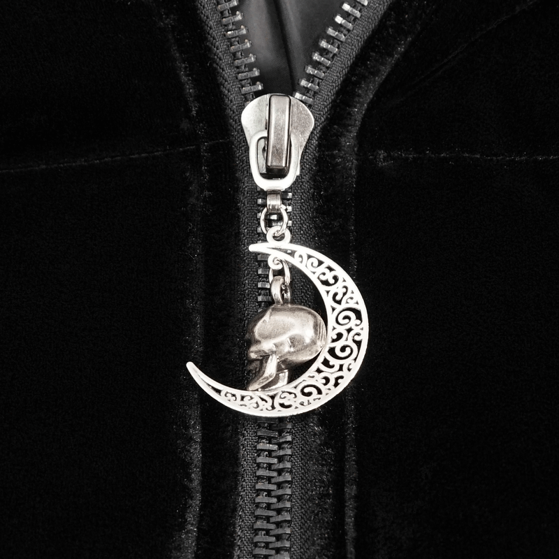 Close-up of gothic zipper with a silver skull and moon charm on a black faux fur hooded cape.