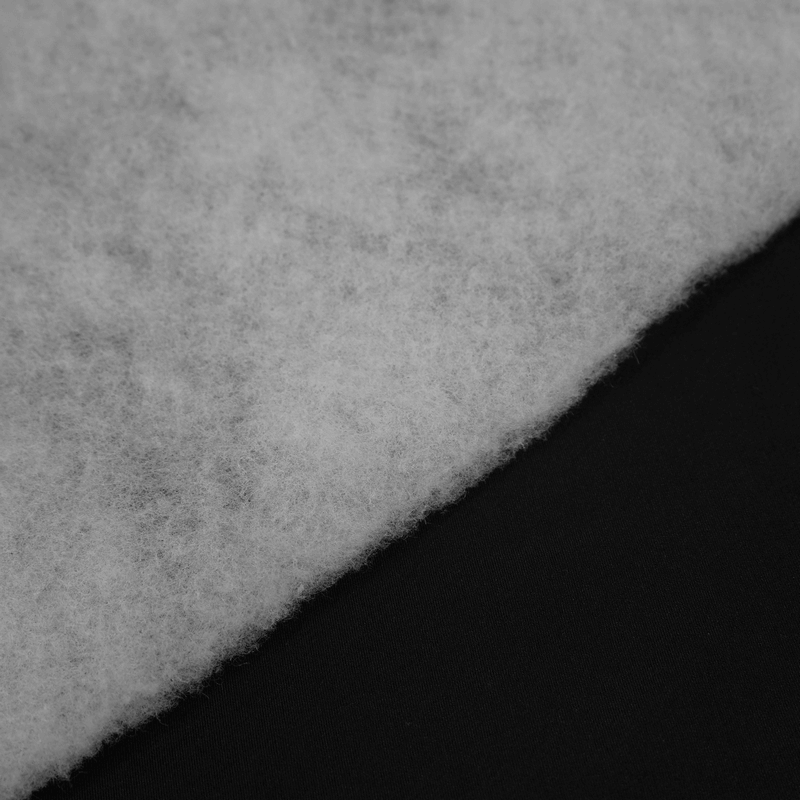 Close-up of soft white fluff against sleek black fabric, ideal for showcasing texture contrast in design or craft projects.