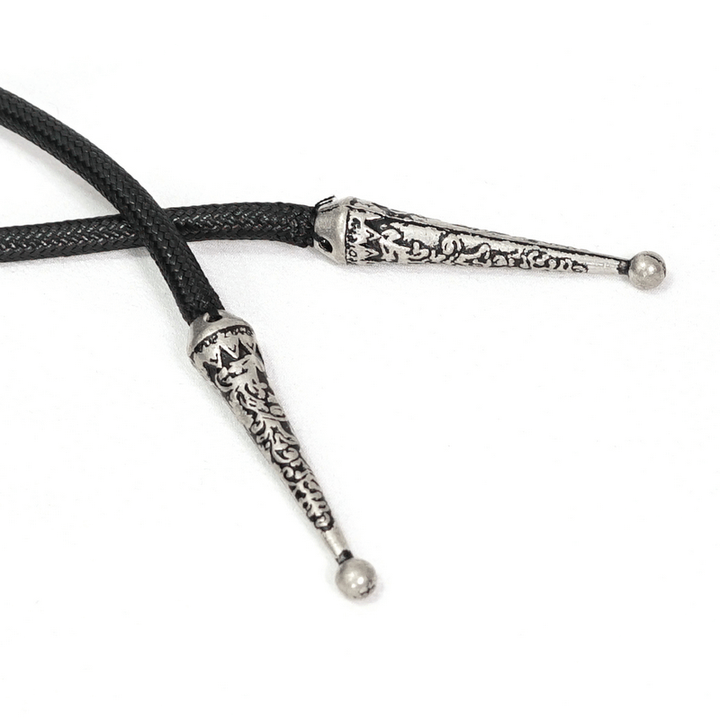 Close-up of decorative silver tips on a black braided bolo tie, showcasing intricate detailing and style.