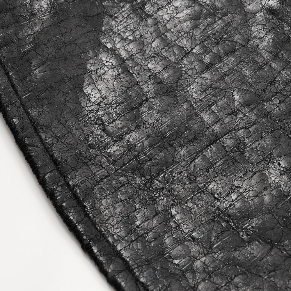 Close-up of gothic faux leather fabric showcasing its textured black surface, perfect for punk-inspired fashion.