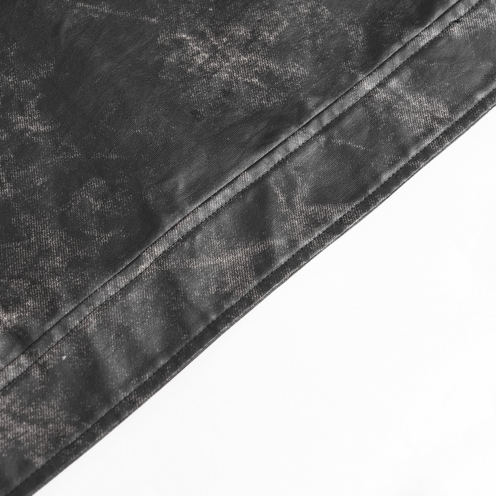 Close-up of the distressed black texture of a gothic faux leather vest, showcasing its unique design and fabric details.