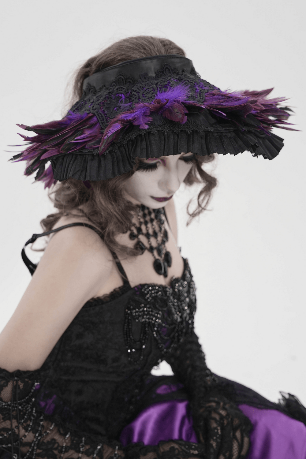 Gothic Feather Halo Bonnet Headdress for Women worn by a model with dark fantasy attire and dramatic feather accents.