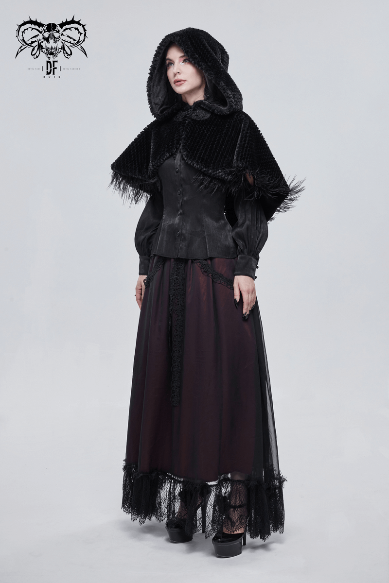 Gothic women's black hooded cape with feathers and fur balls, styled with vintage elegance and a flowing skirt.