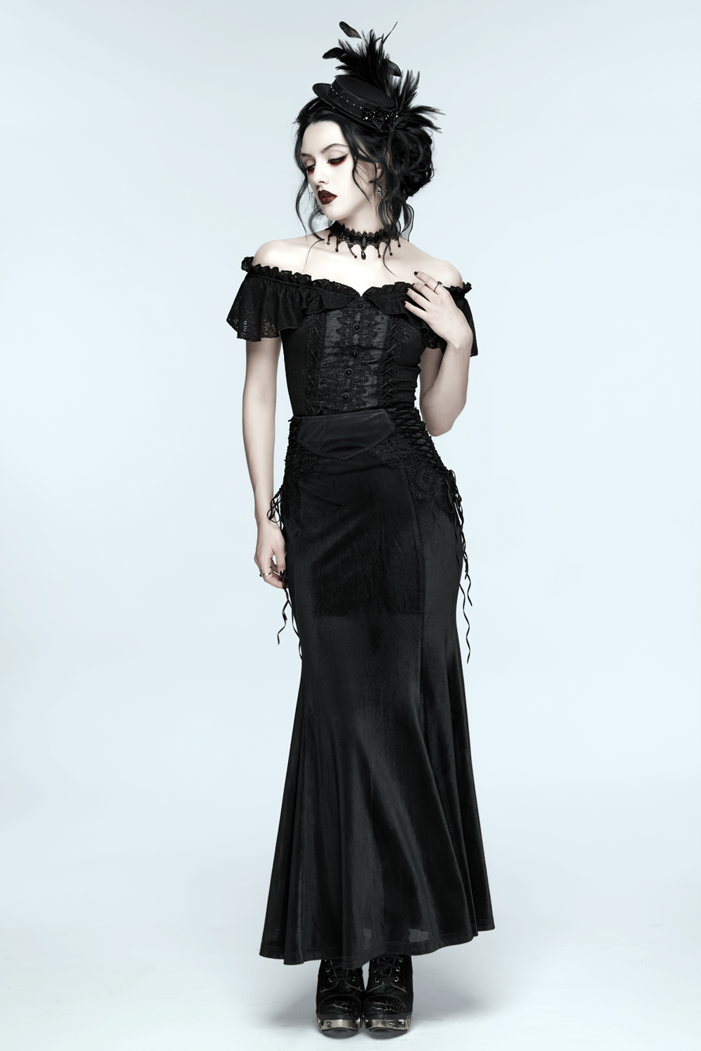 A stunning model wearing a Gothic Feather Mini Hat with Ribbons and Vintage Flair, showcasing dark, elegant fashion.