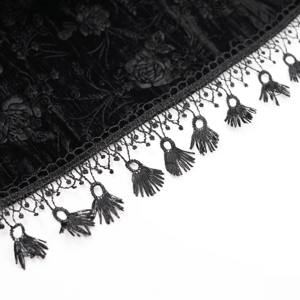 Intricate lace trim with delicate black tassels on a luxurious velvet fabric, ideal for gothic fashion styles.